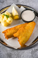 Wall Mural - Deep fried coated fish fillet with potato salad on stone table