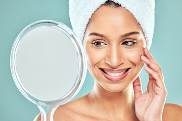 Poster - Happy woman, towel and beauty with mirror in studio for wellness, health or face treatment. Female person, skincare and cosmetic for results, pride in dermatology for glowing skin in blue background