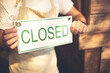 © JorSons/peopleimages.com - Small business, closed sign and hands of person by coffee shop, restaurant or cafe by storefront. Store, man or owner with poster, notification or signage with service information for end of work day