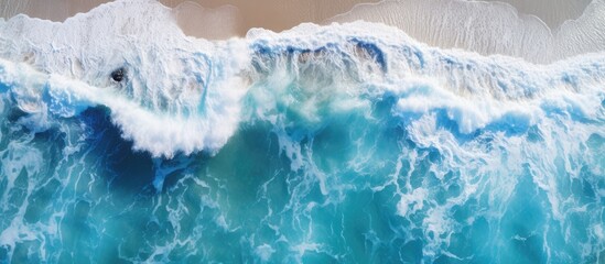 Canvas Print - Aerial view of a coastal scene with vivid ocean colors captured by a drone featuring powerful waves with a spacious backdrop perfect for a copy space image