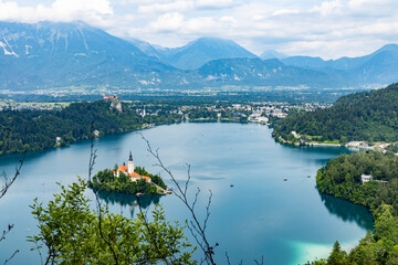 Panoramic view from Lake Bled, beauty heritage in Slovenia. Island with church and castle in the background create a dream setting. View from Ojstrica and Mala Osojnica with the heart-shaped bench.