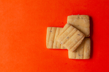 Wall Mural - Stacked Cumin Cookies or Indian Jeera Cookies, on an orange background. Top-down view. Food Flat lay.