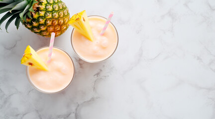 Wall Mural - flat lay, two thick pineapple smoothies without bubbles in glasses with pink and white striped straws, white marble