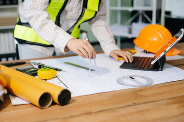 Wall Mural - businessman hand working and laptop with on on architectural project at construction site