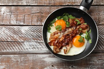Sticker - Tasty bacon, eggs and parsley in frying pan on wooden table, top view. Space for text