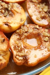 Wall Mural - Tasty baked quinces with walnuts and honey in bowl, closeup