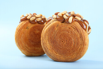 Wall Mural - Supreme croissants with chocolate paste and nuts on light blue background, closeup. Tasty puff pastry