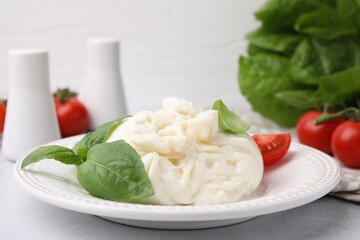 Poster - Delicious burrata cheese, tomatoes and basil on light table, closeup