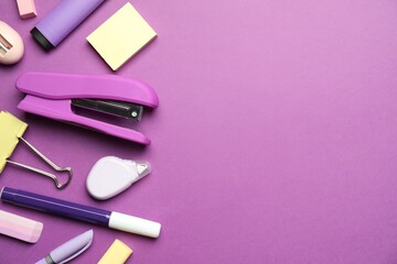 Wall Mural - Flat lay composition with stapler and different stationery on violet background, space for text