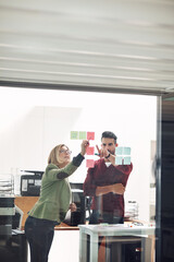Wall Mural - Business people, planning or sticky note on glass in office, creative or teamwork for meeting. Man, woman and startup with writing for job on wall, entrepreneurs with research or brainstorming