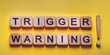 © Fotema - Mental triggering concept. Trigger warning message on a yellow background.