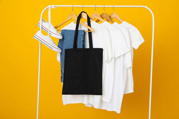 Sticker - A black bag hangs on a hanger with clothes