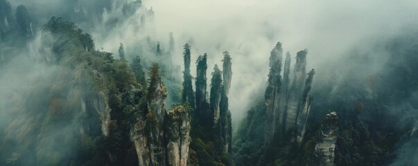 Wall Mural - Aerial view of the Zhangjiajie National Forest Park in China, with towering rock formations shrouded by morning mist.