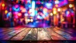 © Aleena - Wooden table with blurred background of night club interior at dark, bokeh lights and colorful light effects with space for text copy