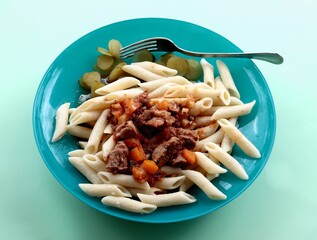 Wall Mural - pasta with meat goulash and sor cucumbers salad