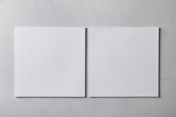 Wall Mural - Blank paper sheets on grey textured background, top view. Mockup for design
