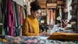 © The Little Hut - Fashion designer woman and typing on laptop in shop for email project or online order of fabric in creative startup Serious tailor computer and small business for clothes or textile in : Generative AI