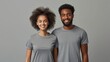 © AlfaSmart - Man and woman in matching T-shirts standing side by side, grey background