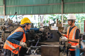 Male workers working with heavy machinery in factory