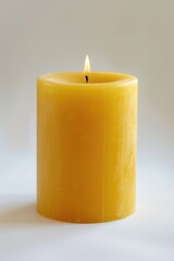 Poster - A yellow candle is lit on a white surface, simple and elegant scene for interior design or decorative purposes