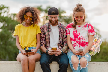 Wall Mural - happy young company of smiling friends sitting in park