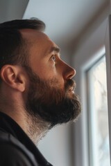 Aufkleber - A person sitting at a window, gazing outside, possibly deep in thought