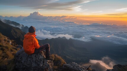 Wall Mural - A man who hikers enjoys a break look at the top of the mountain at sunset adventure travel