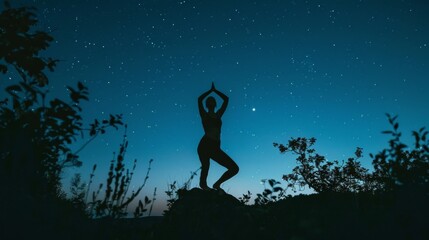 Wall Mural - In the nighttime, a silhouette of an outdoors yoga practitioner is practicing