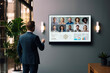 © Przemek Klos - Businessman having online business conference video call with business people on tv screen monitor in board meeting room