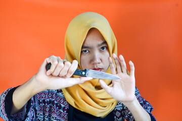 A Muslim Asian woman holding a knife, a mother who will cook for the family