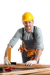 Wall Mural - Male carpenter measuring wooden plank at table on white background