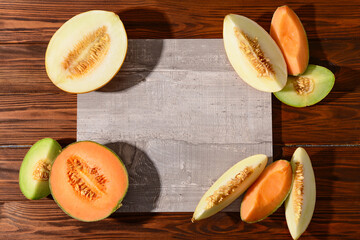 Wall Mural - Pieces of sweet melon with board on wooden background