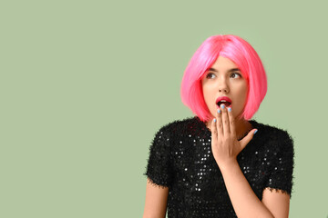 Poster - Portrait of shocked young woman in bright pink wig on green background