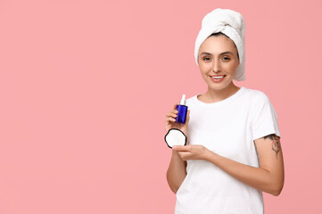 Poster - Young woman with reusable cotton pad and dropper bottle on pink background