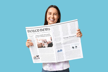 Poster - Beautiful young woman with newspaper on blue background