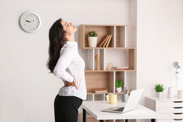 Poster - Beautiful young businesswoman suffering from back pain at office