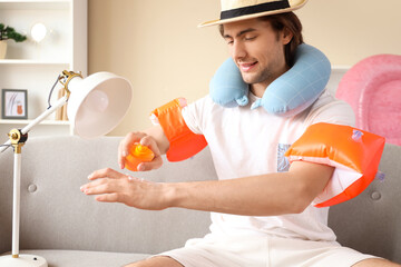 Poster - Male tourist applying sunscreen at home on vacation