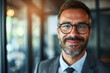 © koala studio - Portrait of a man in a suit smiling and wearing glasses