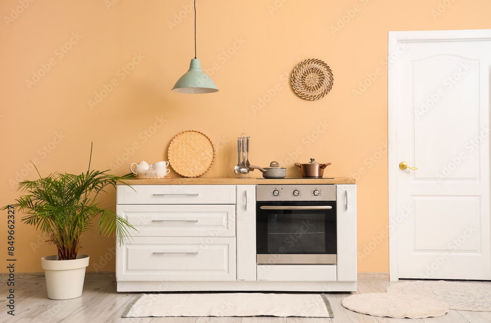 Interior of beautiful kitchen with white counters, oven and lamp