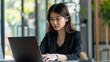© CosmoJulia - Focused Asian businesswoman working on laptop in modern office