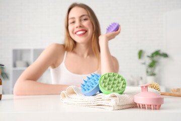 Poster - Hair scalp massagers with towel on table of woman at home, closeup