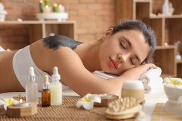 Poster - Young woman with mud on her back lying in spa salon, closeup