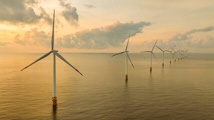 Wall Mural - windmill park with clouds and a blue sky, wind mill turbines in the ocean aerial view of a wind farm