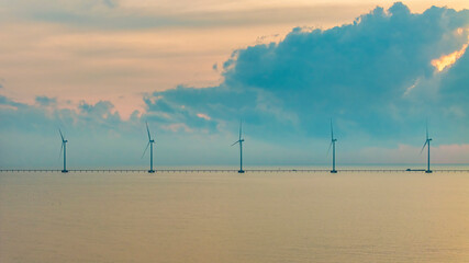 Wall Mural - windmill park with clouds and a blue sky, wind mill turbines in the ocean aerial view of a wind farm