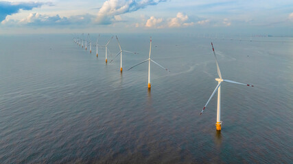Wall Mural - windmill park with clouds and a blue sky, wind mill turbines in the ocean aerial view of a wind farm