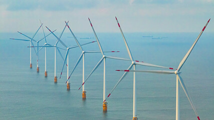 Wall Mural - windmill park with clouds and a blue sky, wind mill turbines in the ocean aerial view of a wind farm