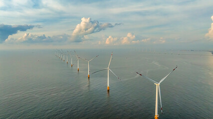 Wall Mural - Windmill park with clouds and a blue sky, wind mill turbines in the ocean aerial view of a wind farm in the Ba Dong beach, Tra Vinh, Vietnam production clean energy