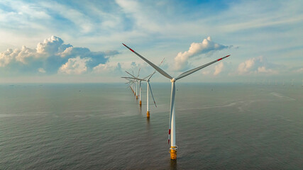 Wall Mural - windmill park with clouds and a blue sky, wind mill turbines in the ocean aerial view of a wind farm