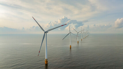 Wall Mural - windmill park with clouds and a blue sky, wind mill turbines in the ocean aerial view of a wind farm