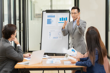 A team of Asian businessmen meets on a company budget to analyze and discuss the financial report situation in the conference room. investment consultant financial advisor